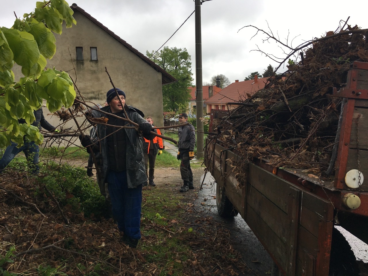 Foto 1 z akce VYČIŠTĚNO muži nakládající větve podél silnice